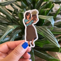 a hand holding a sticker of a woman holding a plant